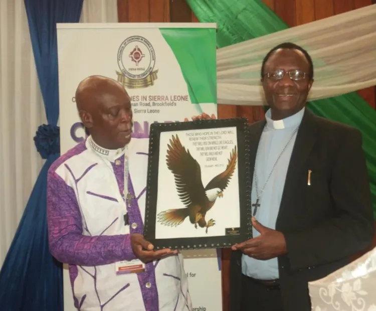 Rt. Rev. Henry Samuels, President of CCSL receiving the gift from AACC General Secretary Rev. Dr. Fidon Mwombeki 